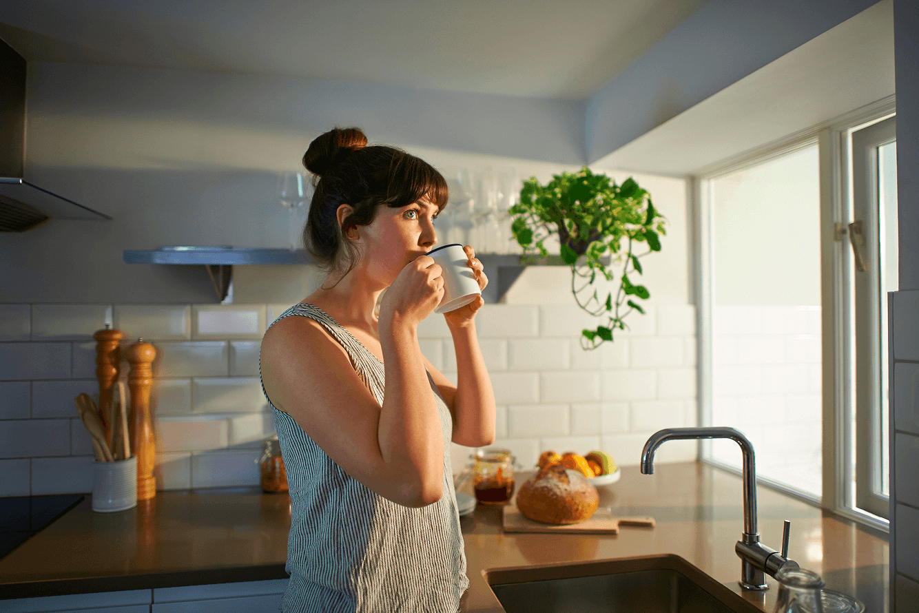 Woman drinking coffee in a modern kitchen